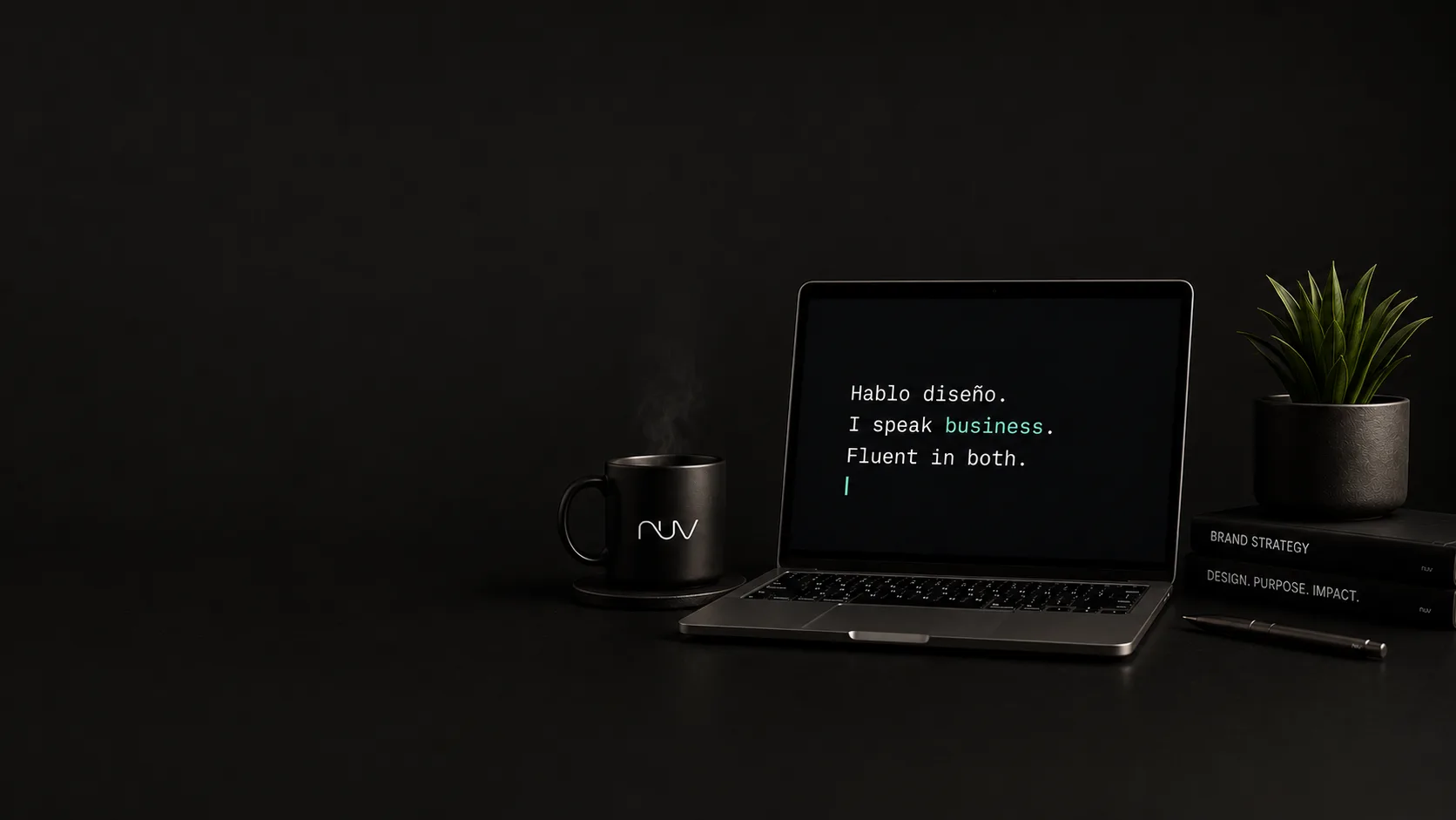 Nuvcreatives workspace with laptop and branded coffee mug